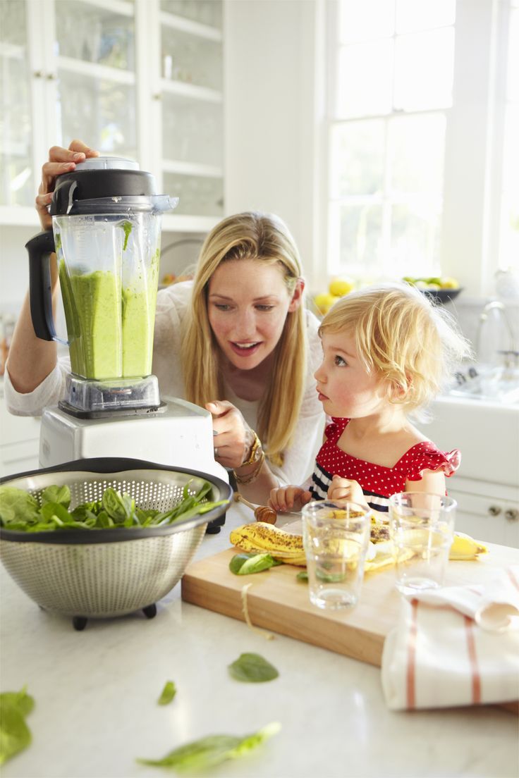 a child with his mother prepares a vegetable smoothie